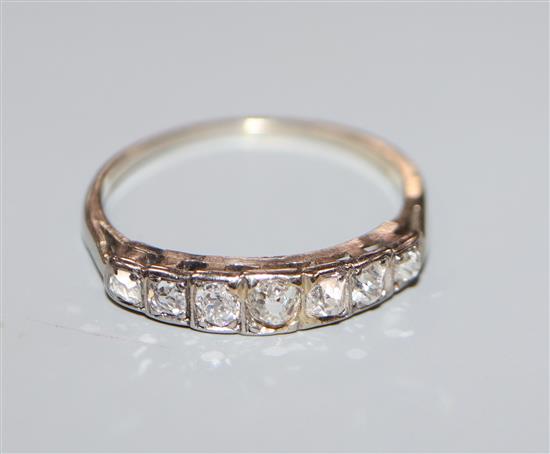 A white metal and graduated seven stone diamond half hoop ring, size K.